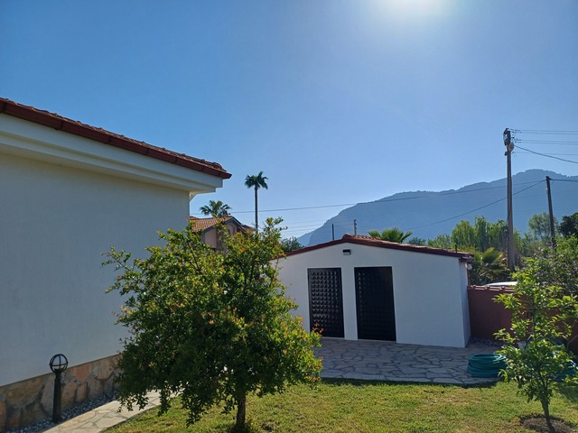Side garden with depot and pool house in the background